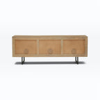 Homecrest Thayer media stand in natural mango wood with rattan panels and black metal legs, back view.