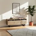 Homecrest Thayer media stand in natural mango wood with rattan cabinet doors and black metal legs in a living room.