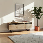 Homecrest Thayer media stand in natural mango wood with rattan cabinet doors and black metal legs in a living room.