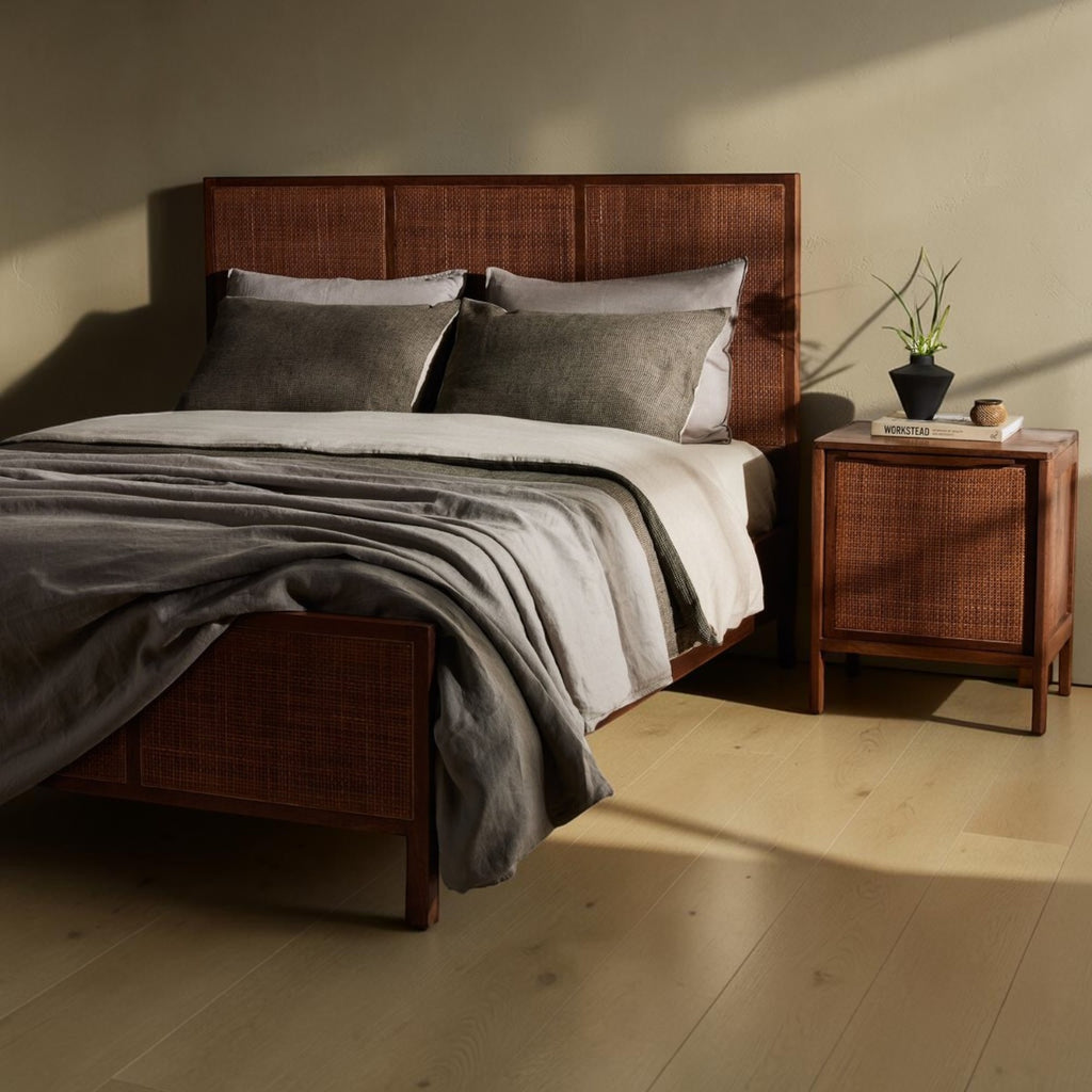 Homecrest walnut mango wood bed with a woven rattan headboard and matching bedside table in a warm bedroom setting