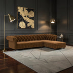 Homecrest Wardour L-shaped brown velvet Chesterfield sofa with tufted back and brass nailhead trim in a dark room.