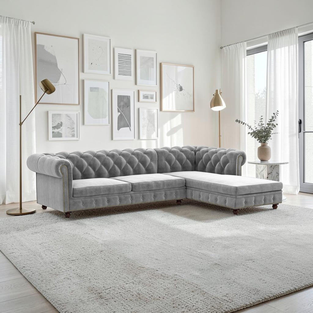 Homecrest Wardour L-shaped grey velvet Chesterfield sofa with button tufting and nailhead trim in a bright living room