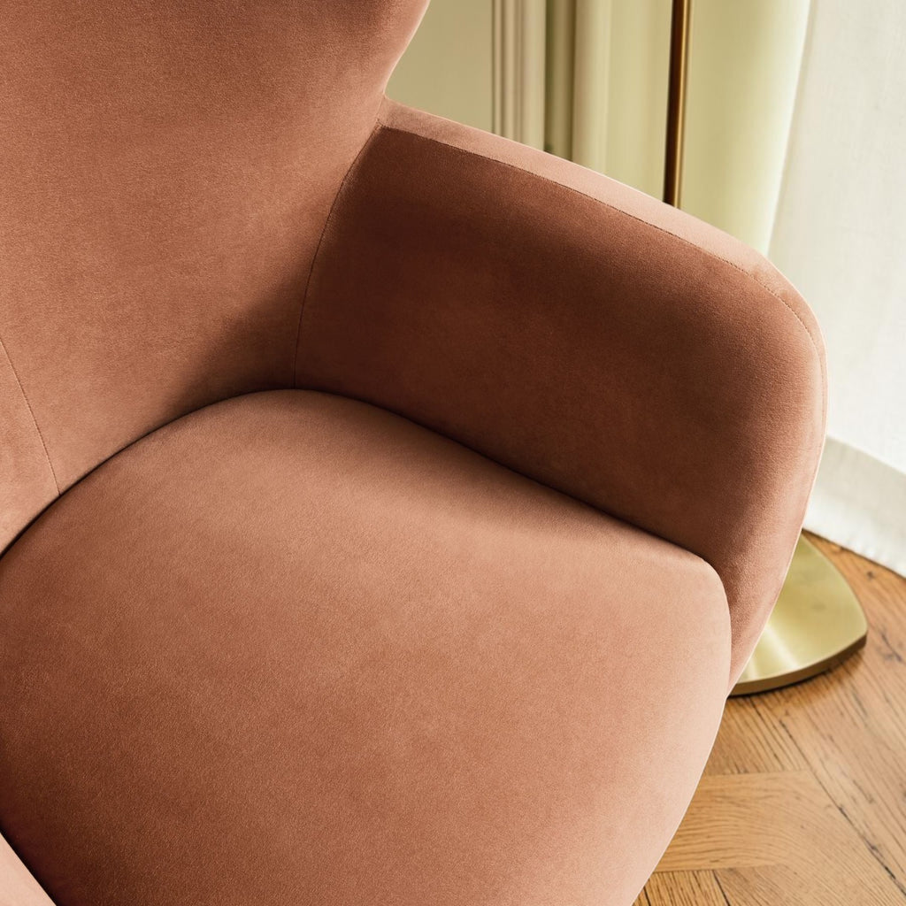 Homecrest Yannick wing-arm accent chair in plush truffle pink velvet with curved armrests on a textured orange rug.