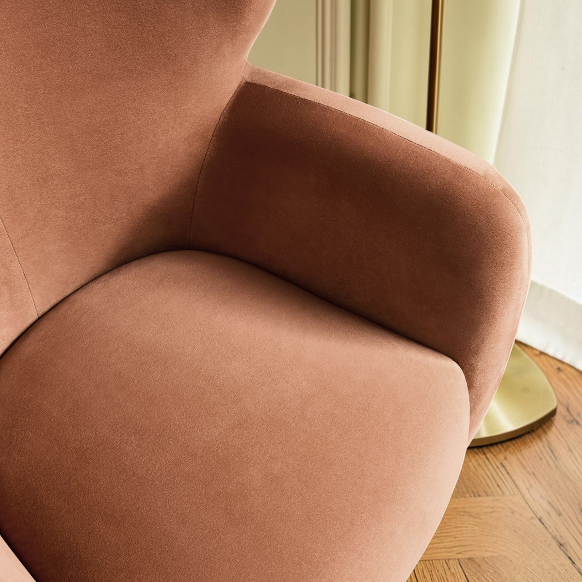 Homecrest Yannick wing-arm accent chair in plush truffle pink velvet with curved armrests on a textured orange rug.